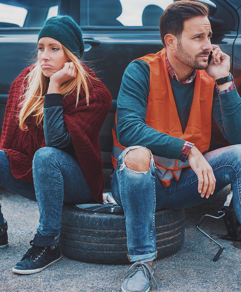Drivers waiting for roadside help after a flat tire